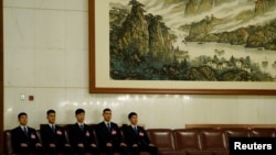 2018年3月18日在北京人民大會堂舉行的全國人民代表大會全體會議上，安全人員坐在他們的座位上，姿勢整齊劃一。
