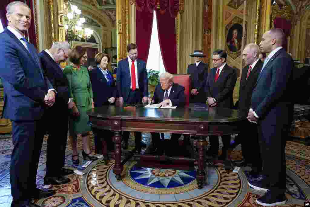 O Presidente Donald Trump, ao centro, participa numa cerimónia de assinatura na Sala do Presidente, a 20 de janeiro de 2025, no Capitólio dos EUA, em Washington.