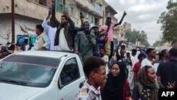 Pessoas saem para as ruas de Porto Sudão para celebrar o avanço das forças militares sudanesas e dos grupos armados aliados sobre a capital do estado de Al-Jazira, Wad Madani, detida pelas Forças de Apoio Rápido (RSF) paramilitares, a 11 de janeiro de 2025.
