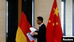 在北京举行中德经贸部长会议期间一名男子走过中国和德国国旗。（资料照片）
