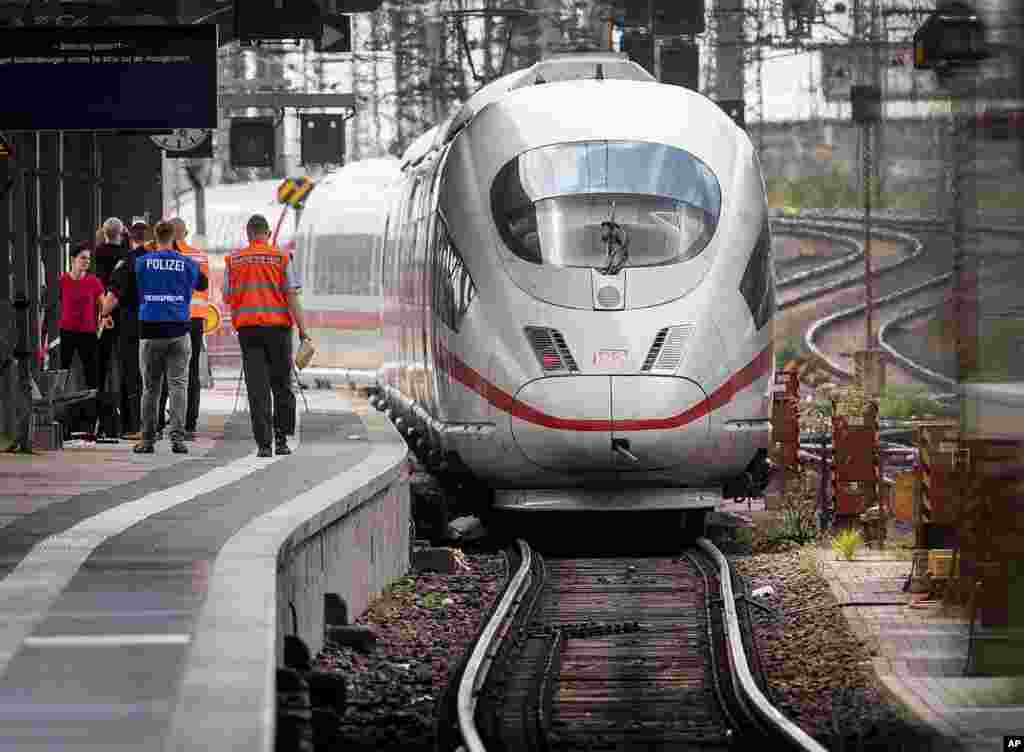 A police officer walks next to an ICE highspeed train at the main station in Frankfurt, Germany. An 8-year-old boy was run over by the train and killed at Frankfurt's main station after a man pushed him and his mother onto the tracks. The mother was able to escape but the boy suffered fatal injuries.