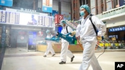 工作人員在北京火車站噴灑消毒劑。（2020年6月18日）