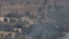 FILE - Smoke and fire rise in the Quneitra province as Syrian rebels clash with President Assad’s forces, as seen from the Israeli controlled-Golan Heights, Aug. 27, 2014. 