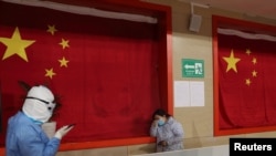 2020年2月27日，一名身穿防护服的医生在武汉一方舱医院安抚一位患者。