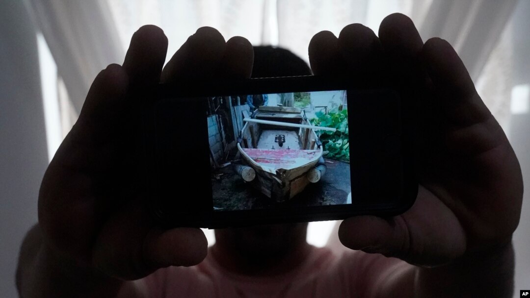 En esta foto del martes 21 de junio de 2022 en North Miami Beach, Florida, un migrante cubano que pidió no ser identificado por temores a la seguridad de su familia que vive en la isla, muestra una foto del bote rudimentario que fabricó para salir de Cuba junto a tres amigos.
