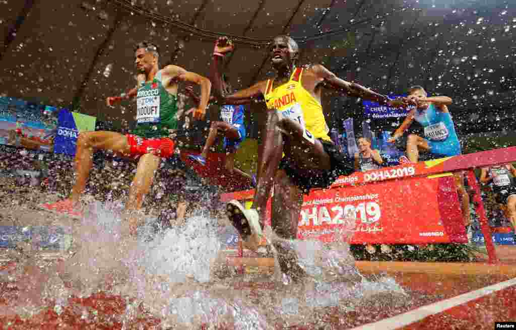 Uganda's Benjamin Kiplagat, left, and Morocco's Mohamed Tindouft, right, compete in the Men's 3000m steeplechase heats at the 2019 IAAF Athletics World Championships in Doha, Qatar.
