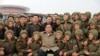 This undated picture released from North Korea's official Korean Central News Agency, Nov. 18, 2019, shows North Korean leader Kim Jong Un posing with members of the Air and Anti-Aircraft Force of the Korean People's Army.