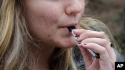 ARCHIVO - En esta gráfica del 11 de abril de 2018, una joven de 15 años no identificada consume marihuana con un cigarrillo electrónico cerca de su colegio en Cambridge , Massachusetts.