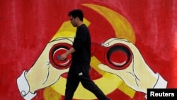 一名男子從上海街頭中共黨徽前走過。（2019年9月25日）