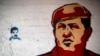 FILE - The painted images of Venezuela's late President Hugo Chavez, right, and current President Nicolas Maduro cover a wall in downtown Caracas, Venezuela.