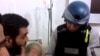 An image grab taken from a video posted by Syrian activists on Aug. 26, 2013 allegdly shows a UN inspector (R) listening to the testimony of a man in the Damascus subburb of Moadamiyet al-Sham.